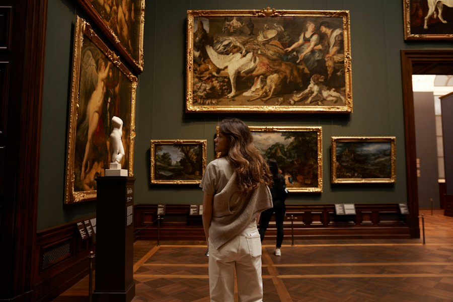 Besucherin betrachtet Arbeiten in einem hellen Ausstellungsraum