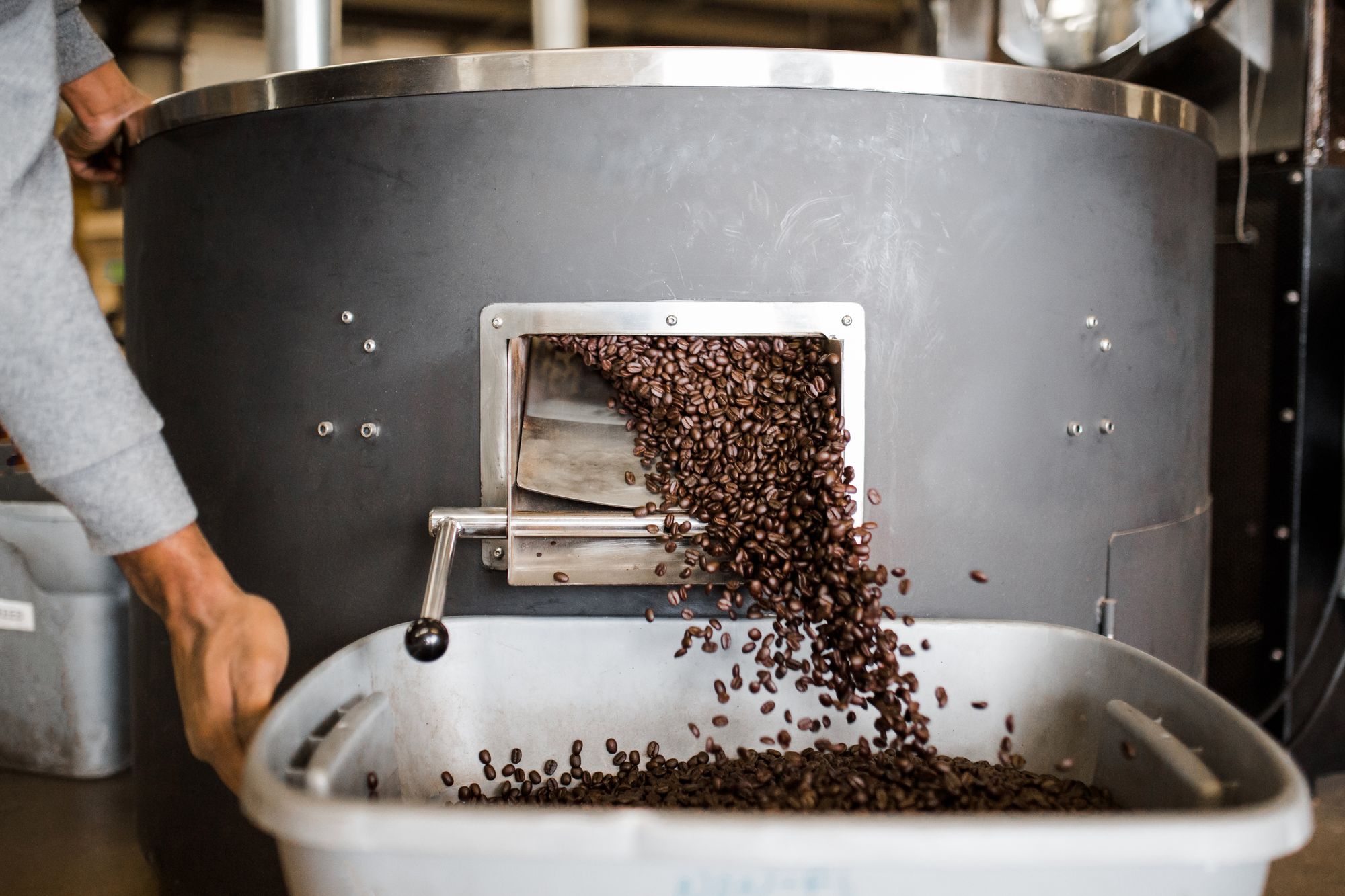 Kaffeebohnen werden in eine Röstmaschine gefüllt